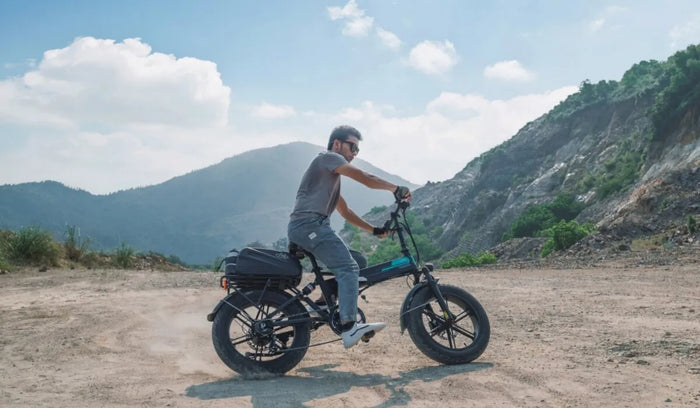 A man is riding a large Fiido M1 Pro bike through the mountains.