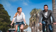 A man and a woman ride Fiido electric bicycles on the street.