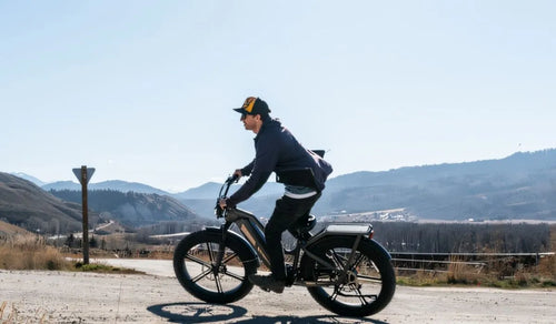 A man rides a Fiido Titan e-bike on a paved road.