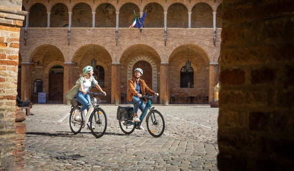 A man and a woman riding Fiido electric bicycles in the city