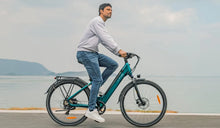 A man rides a Fiido C11 Pro electric bike by the river