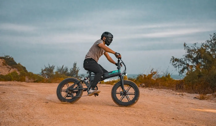 A man riding a Fiido M1 PRO fat tire electric bike speeding through the mountains