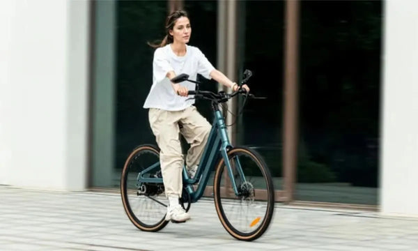 A woman rides a Fiido C11 electric bike in the city.