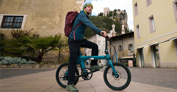 A rider on a Fiido X electric bike in a historic  town.