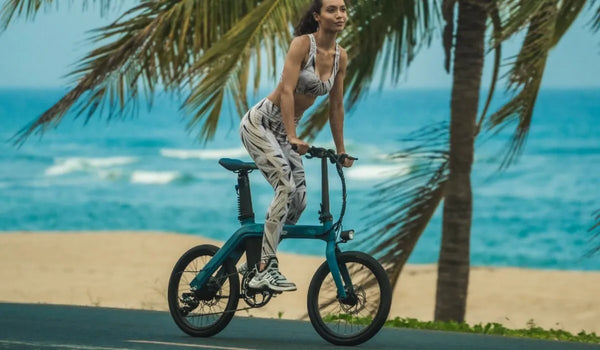 A fit woman is riding a fiido D11 electric bike on the beach