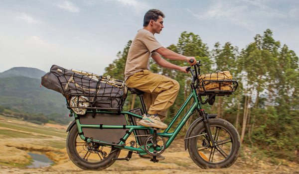 Man riding a Fiido T2 electric bicycle carrying camping tools