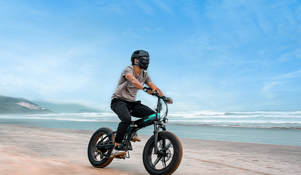 Uomo che guida la bici elettrica FiidoM1pro sulla spiaggia