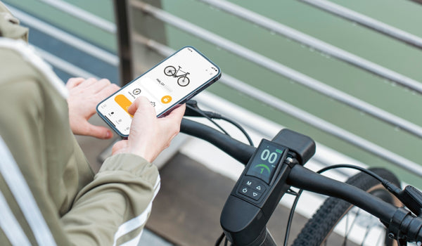 A woman is using the Fiido APP to connect a Fiido e-bike.