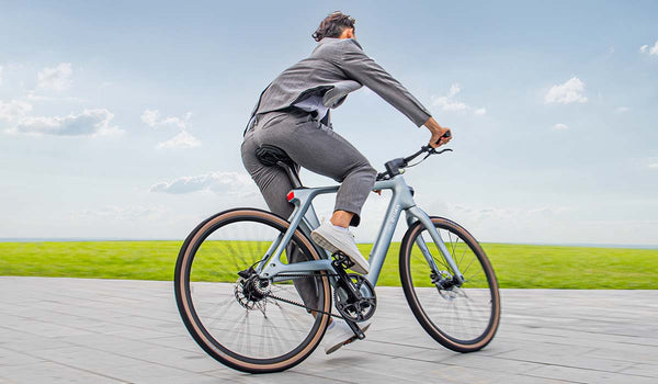 A man rides a Fiido Air quickly in an open field.