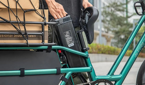 A man prepares to service the battery of a Fiido T2 electric bike.