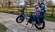 Two children are riding on a Fiido T2 two-seater electric bike.