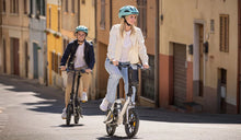 A couple rides a Fiido D3 Pro electric bike on the street.