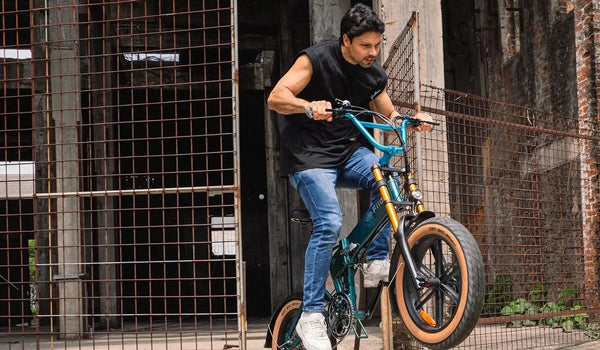 A man is riding a Fiido M1 Pro electric mountain bike on a mountain trail.
