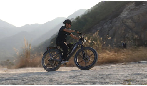 A man is riding a Fiido Titan three-battery electric bike on a long-distance trip.