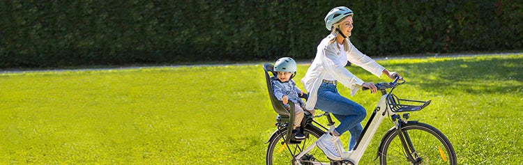 A woman rides a Fiido C11 electric bicycle with her baby