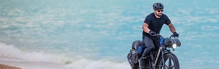 A man rides a Fiido Titan off-road electric bicycle on the beach